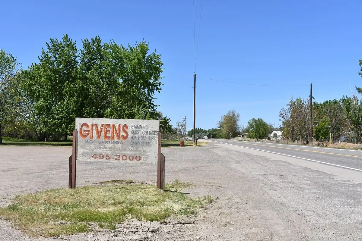 Givens Hot Springs roadside sign listing swimming, guest cottages and camp sites beside the highway