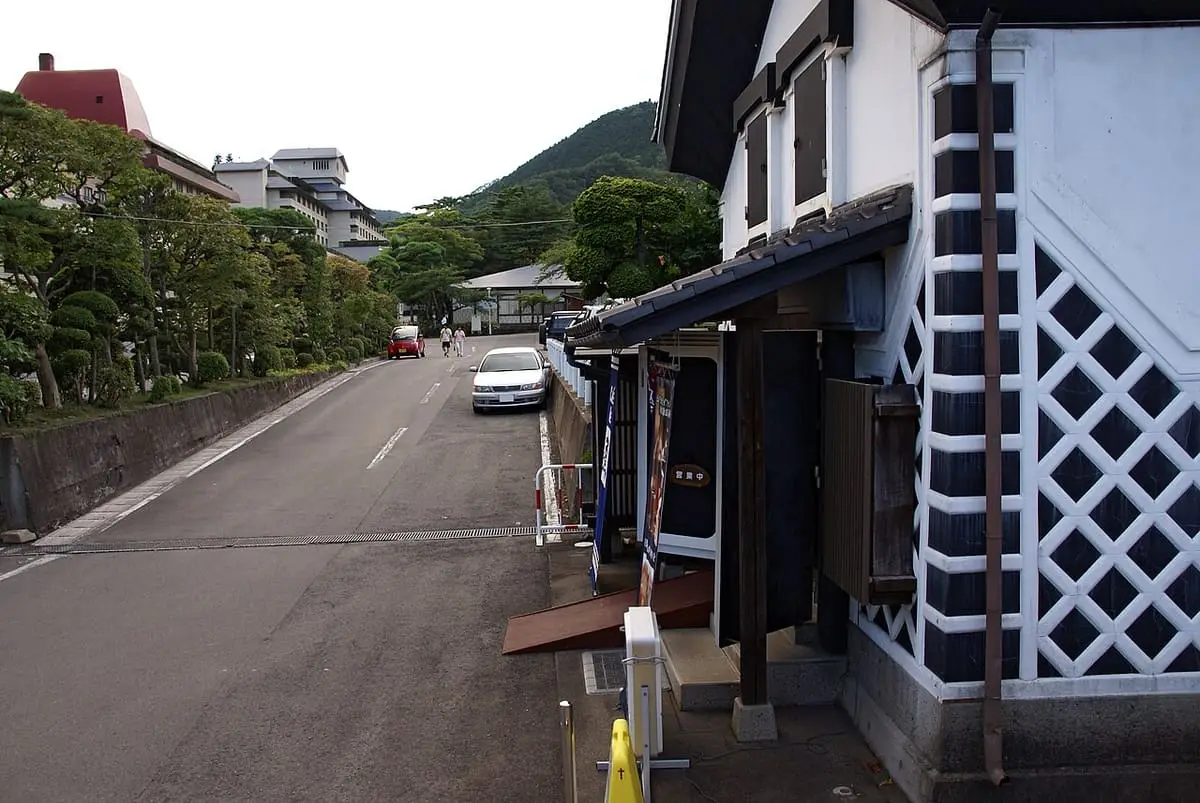 Street with a white storehouse style building in Hanamaki Onsen