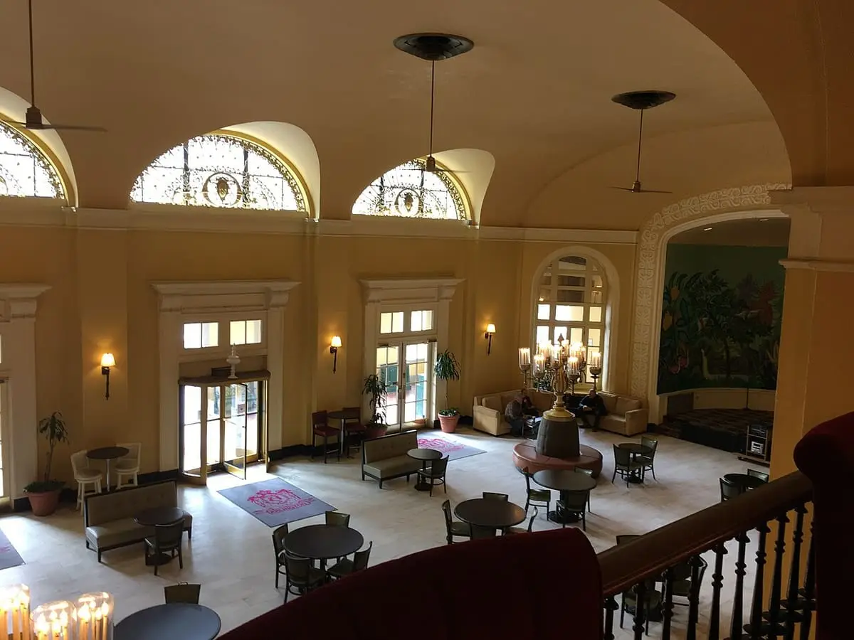 Arched windows, chandeliers and seating in the grand lobby of the Arlington Hotel