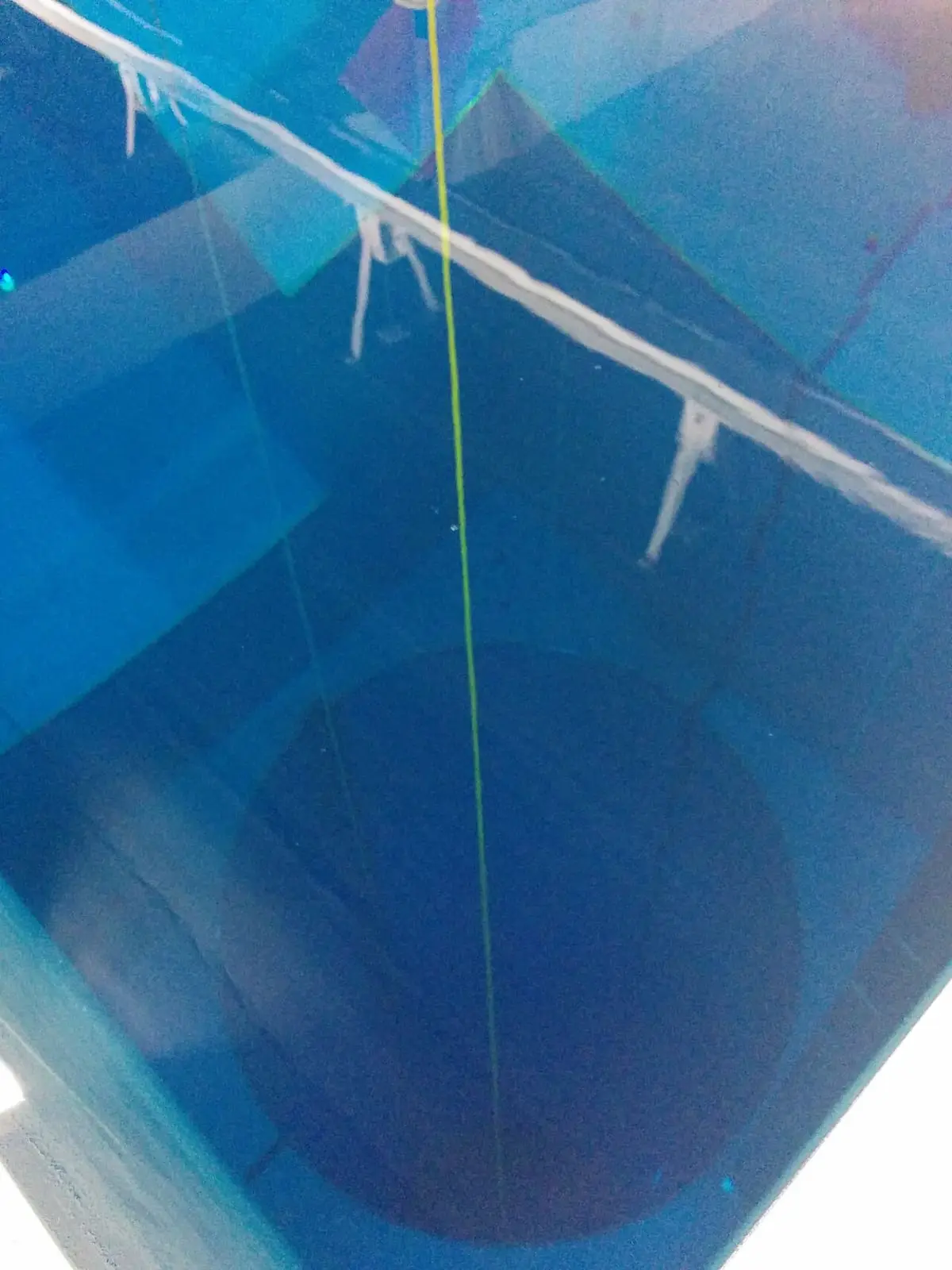 Looking down into the deep blue diving shaft at Terme Millepini from its underwater tunnel