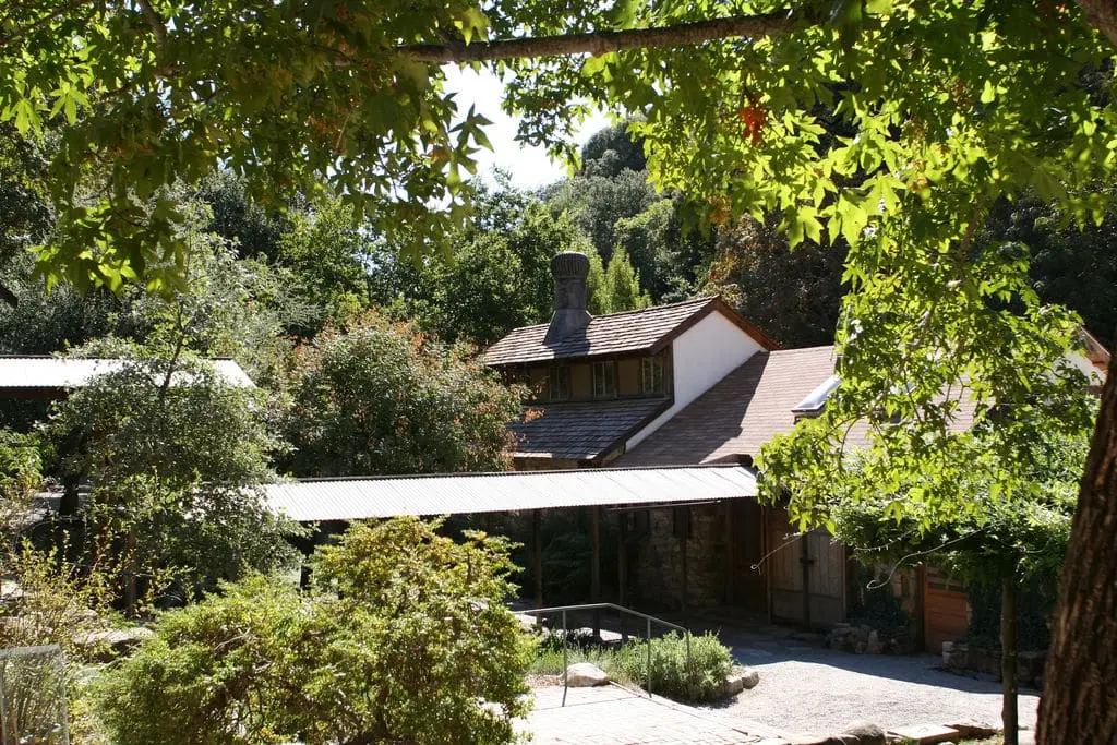 Stone and wood buildings of Tassajara Zen Mountain Center framed by leafy trees
