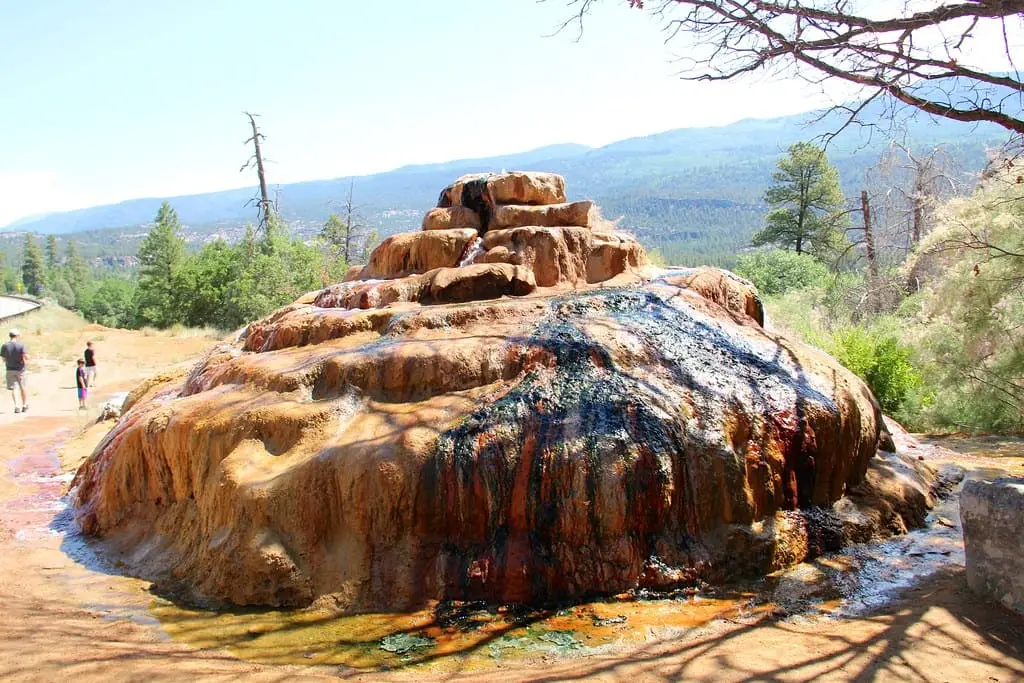 Rust colored travertine mound at Pinkerton Hot Springs with mineral water staining the rocks