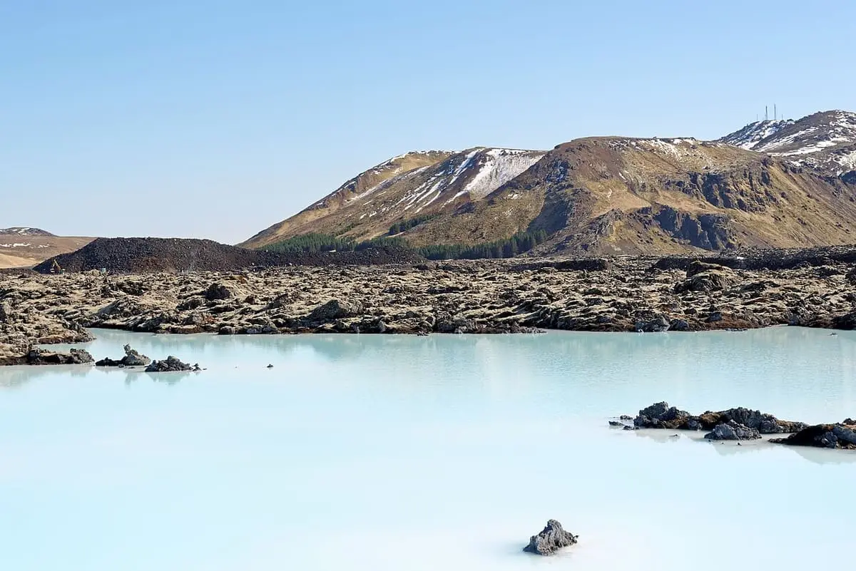 Pale blue Blue Lagoon water and lava field below Thorbjorn mountain in Iceland