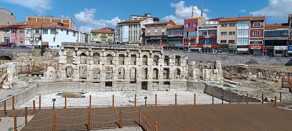 Sarıkaya Roman Bath ruins seen beyond a wooden visitor walkway with town buildings behind