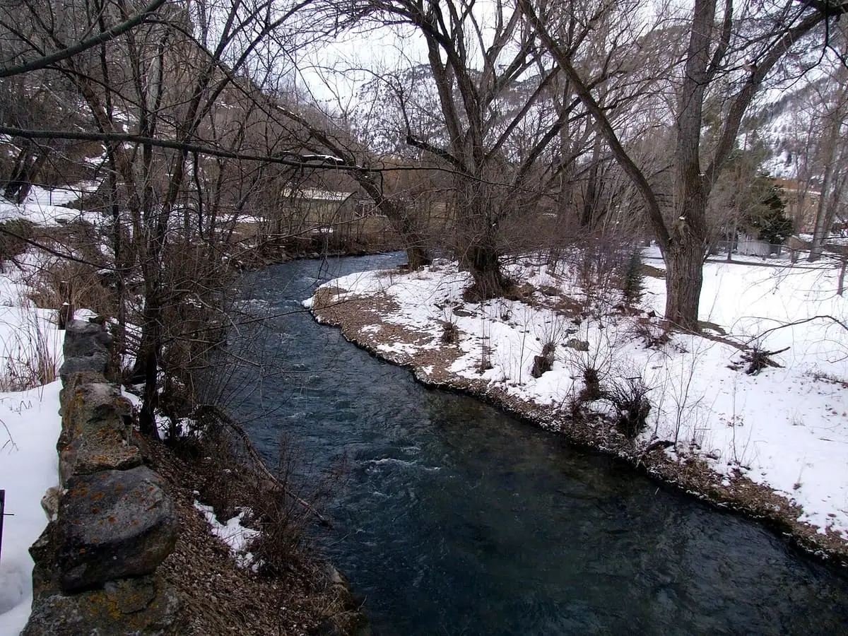 Snowy banks and bare trees along the Portneuf River in Lava Hot Springs in winter
