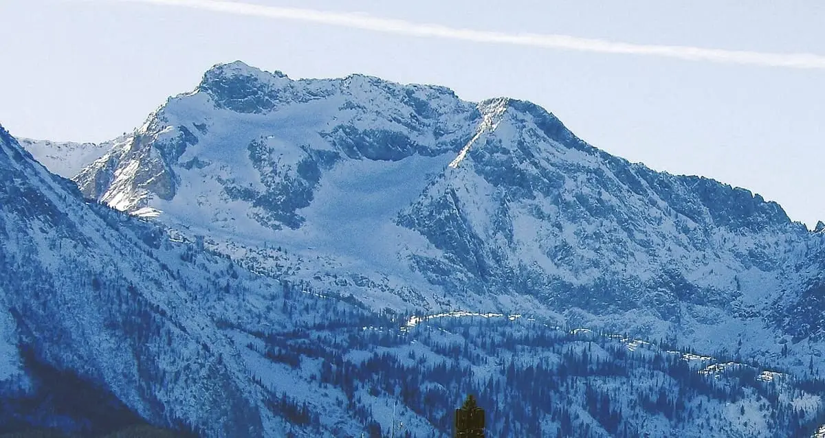 Snowy Merritt Peak rising above forested slopes, seen from Stanley, Idaho