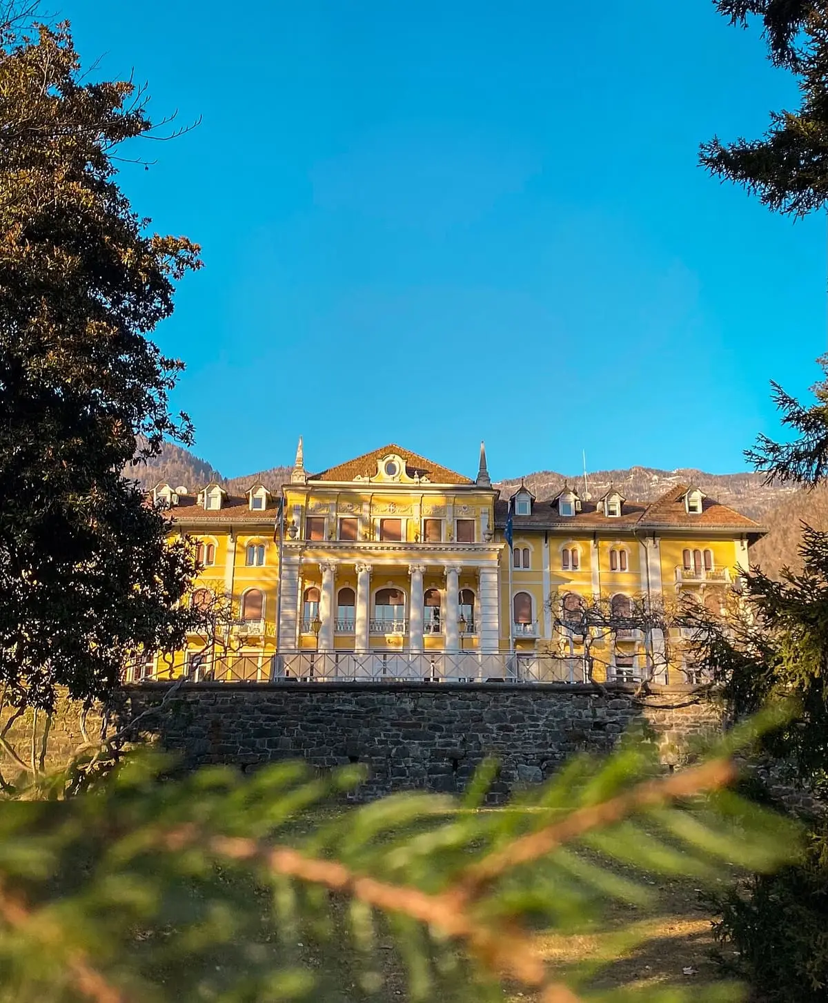Imperial Grand Hotel Terme at the top of the Levico spa park under a blue sky