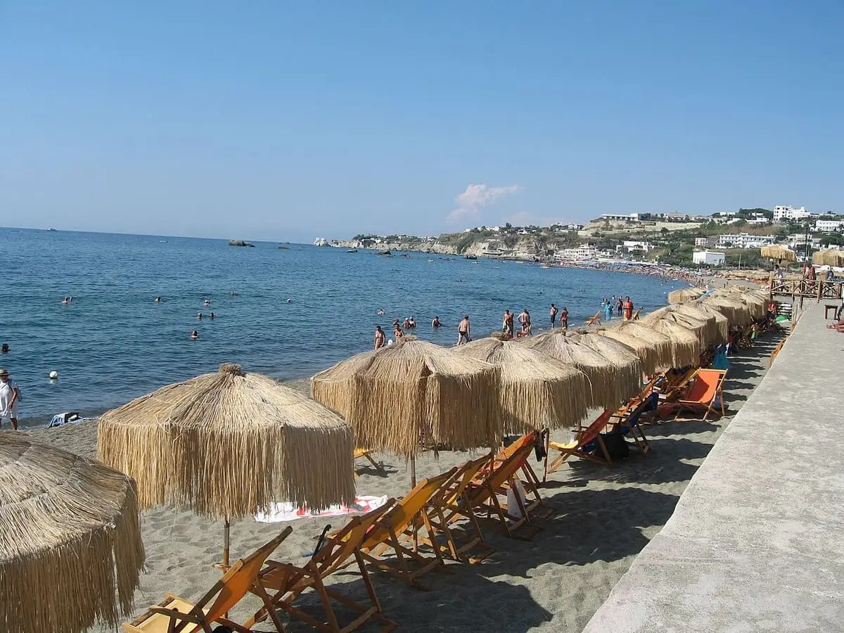 Straw umbrellas and sun loungers lining the beach of Giardini Poseidon on Citara bay