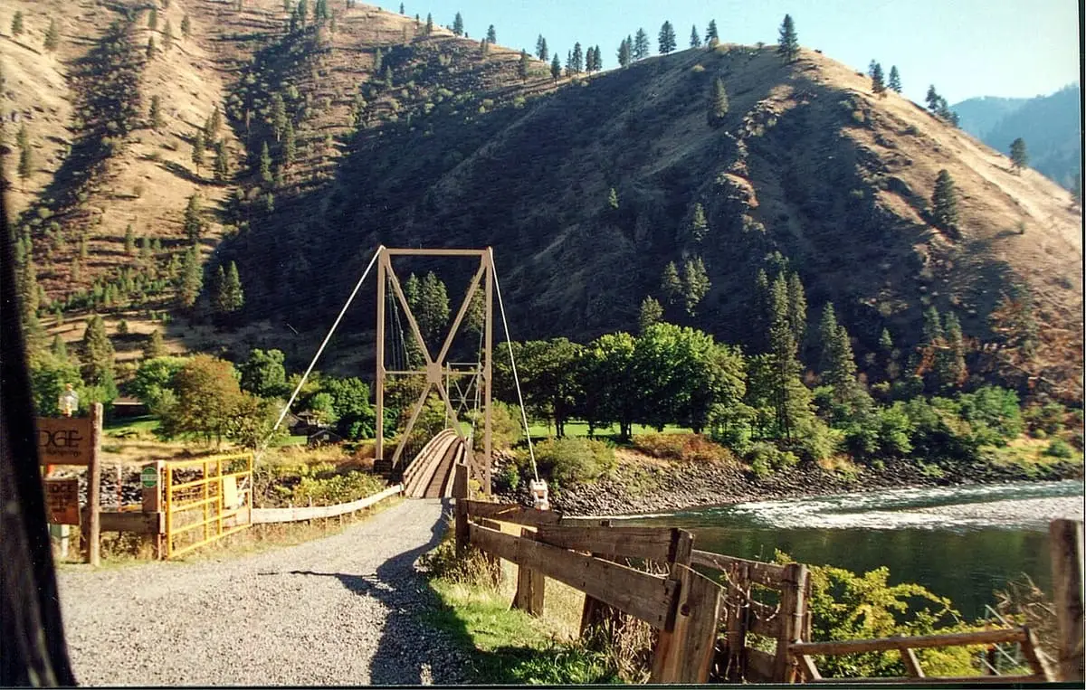 Wooden suspension bridge over the Salmon River below steep dry canyon slopes near Riggins Hot Springs