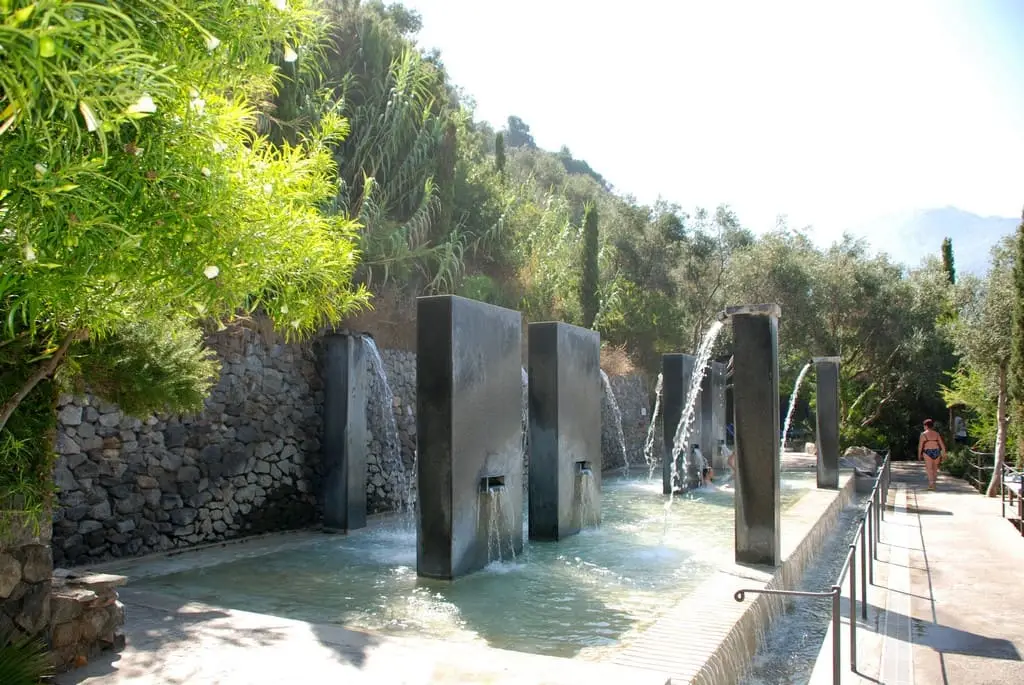 Stone walled Templare pool with modern water spouts among trees at Negombo