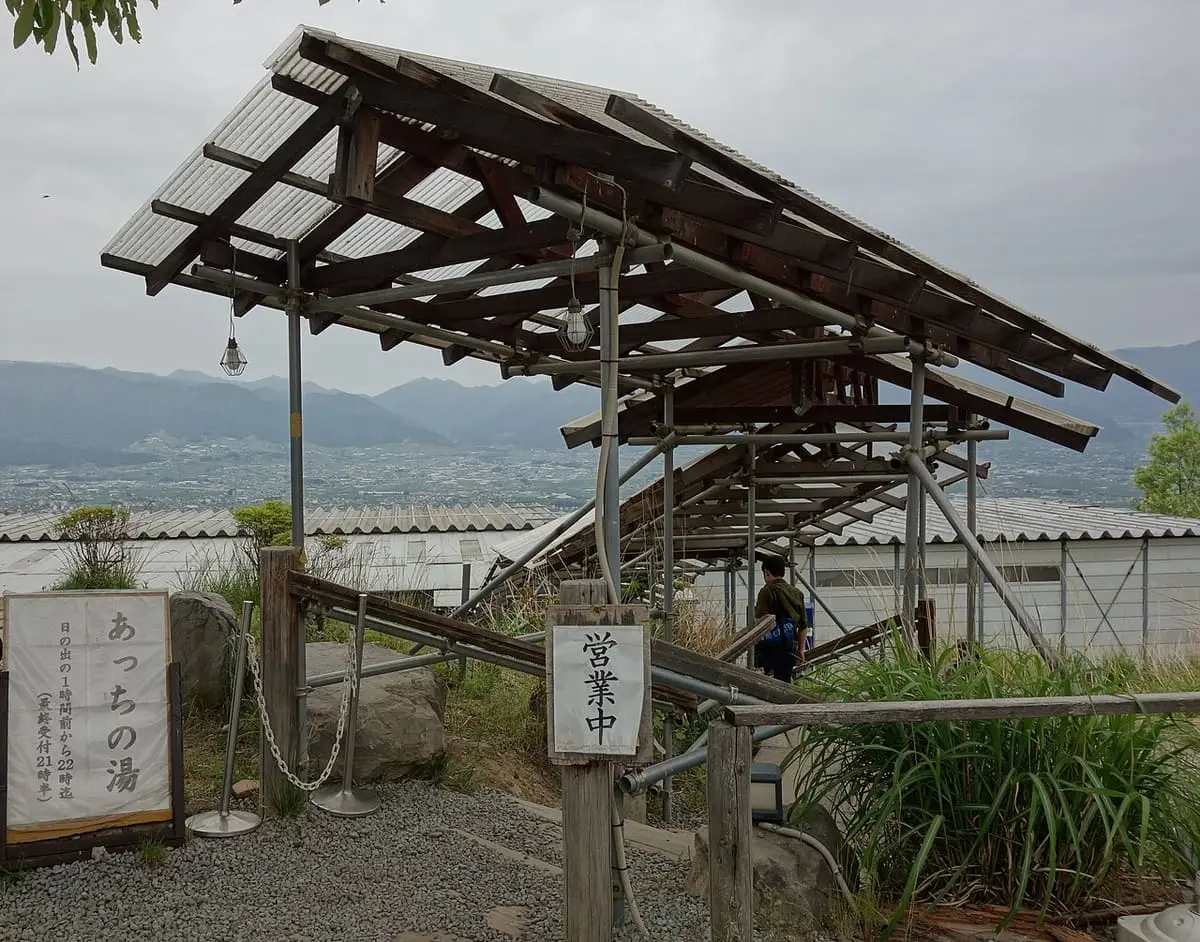 Wooden gate structure and sign at the entrance to Acchi no Yu bath at Hottarakashi Onsen