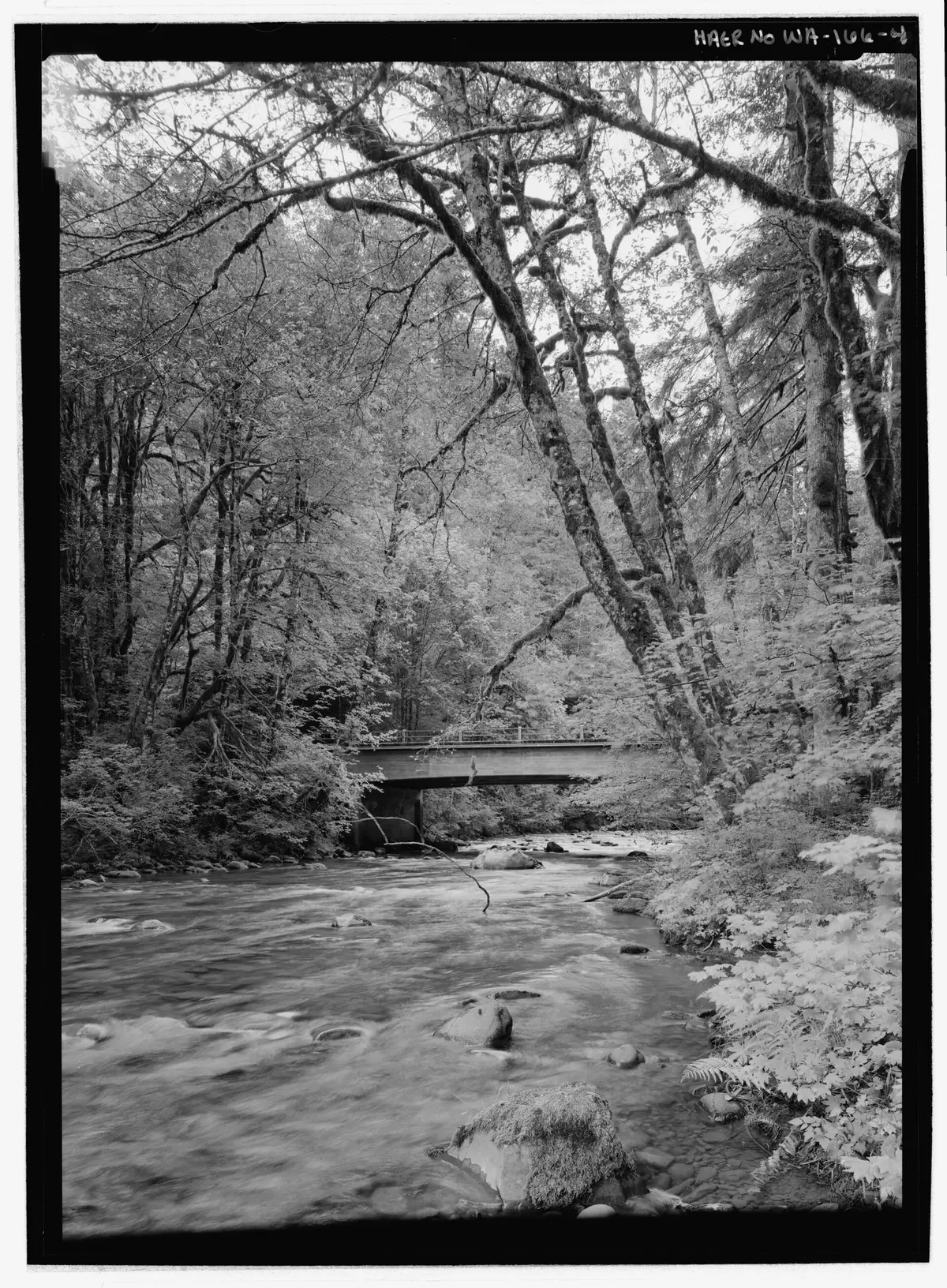 Historic black and white view of the bridge over the Sol Duc River on the road to the resort