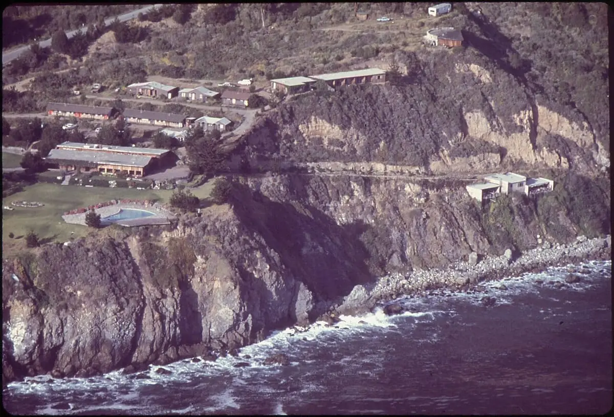Historic aerial view of Esalen buildings and pool on the cliffs above the Big Sur surf