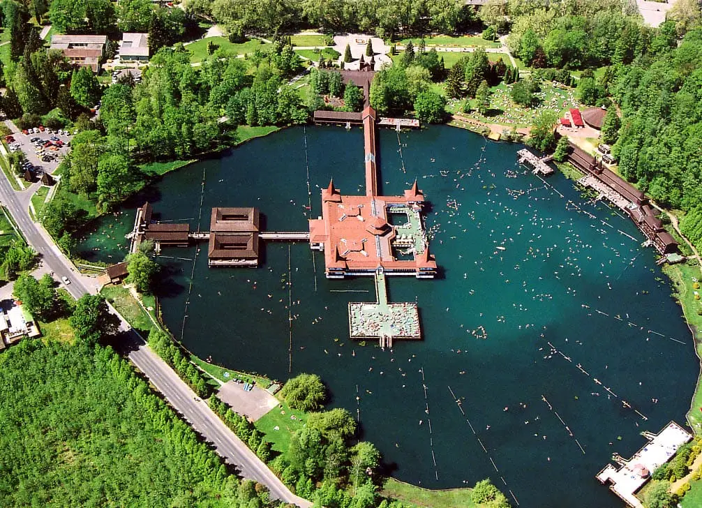 Aerial view of Lake Hévíz with its central pier bathhouse surrounded by forest