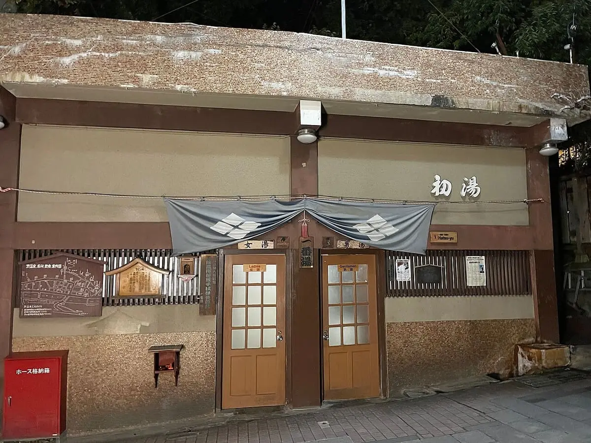 Front of Hatsuyu, the first public bathhouse of Shibu Onsen, with wooden doors and noren