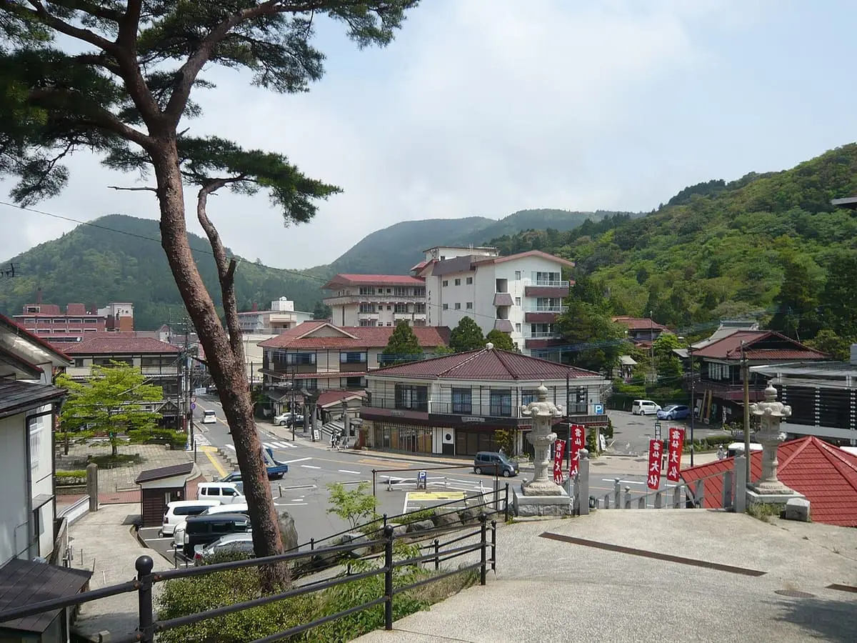 Main street of Unzen Onsen town with hotels set against green mountains