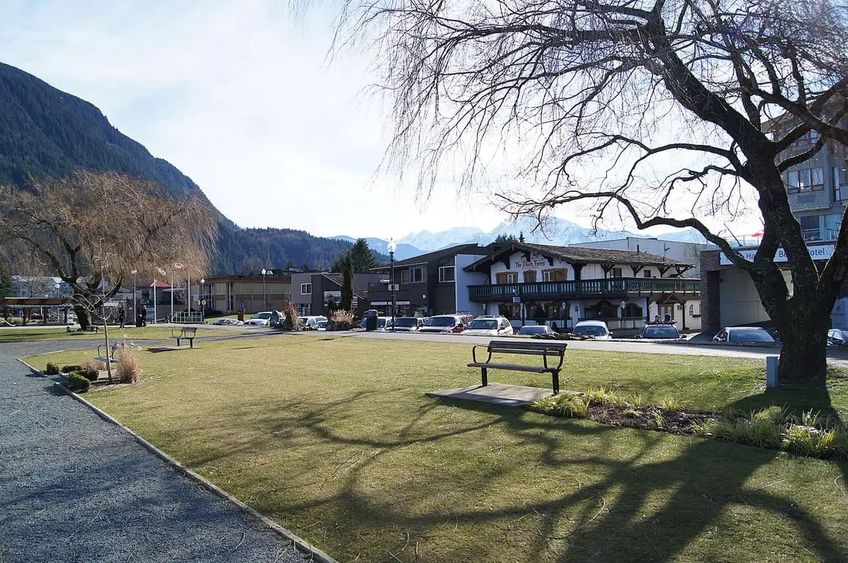 Waterfront lawn and hotels at Harrison Hot Springs with mountains rising behind