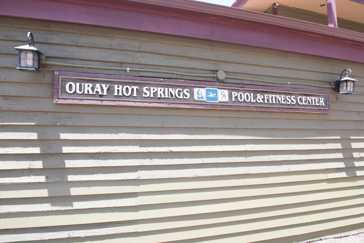 Ouray Hot Springs Pool and Fitness Center sign on a tan clapboard building