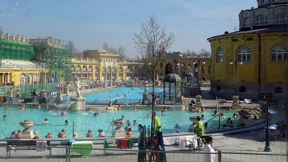 Outdoor thermal pools of the Széchenyi bath framed by yellow bathhouse wings