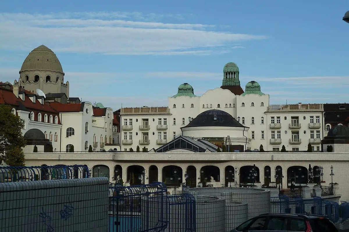 Domes and white facades of the Gellért Bath complex above its terraced outdoor pool area