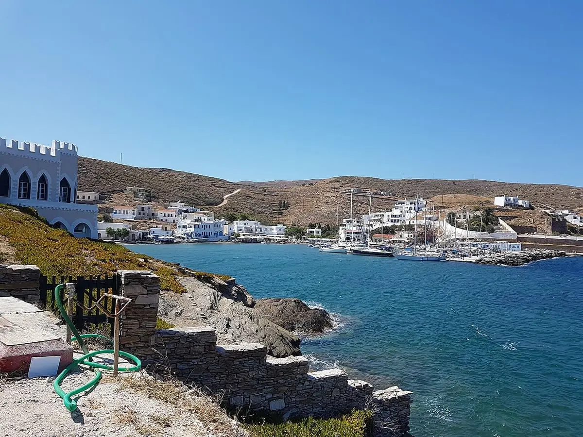Loutra bay on Kythnos with whitewashed houses, moored boats and dry hills under blue sky