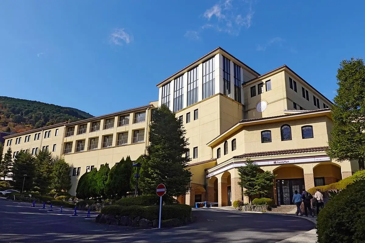Cream colored Hakone Kowakien Yunessun building with tall windows under a blue sky
