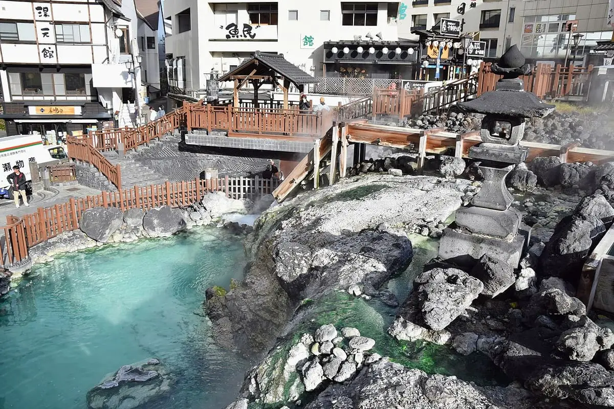 Steaming blue pool and rocks of the Yubatake below the inns of Kusatsu Onsen