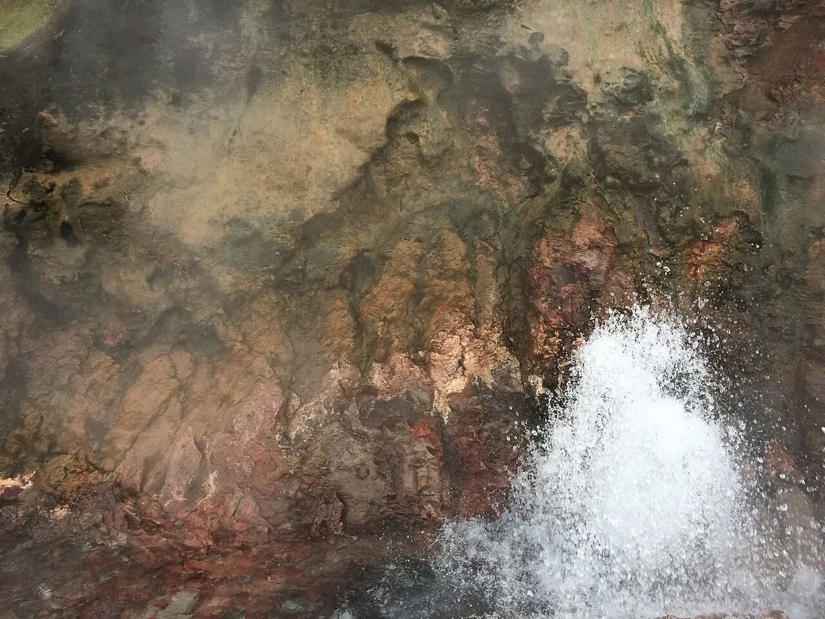 Boiling water bursting from reddish rock at Deildartunguhver hot spring beside Krauma