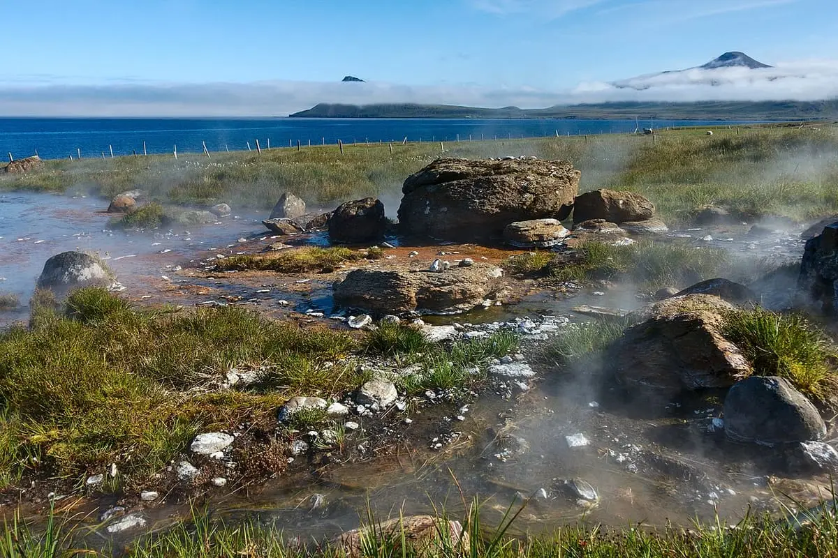 Steaming hot springs among rocks near Norðurfjörður that feed the Krossnes pool