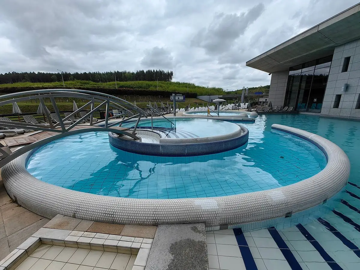 Round outdoor thermal pool with a footbridge at Saliris Resort in Egerszalók