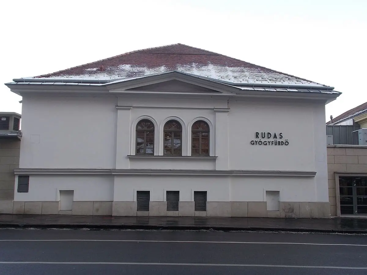 White facade of the Rudas Gyógyfürdő building with arched windows and lettering