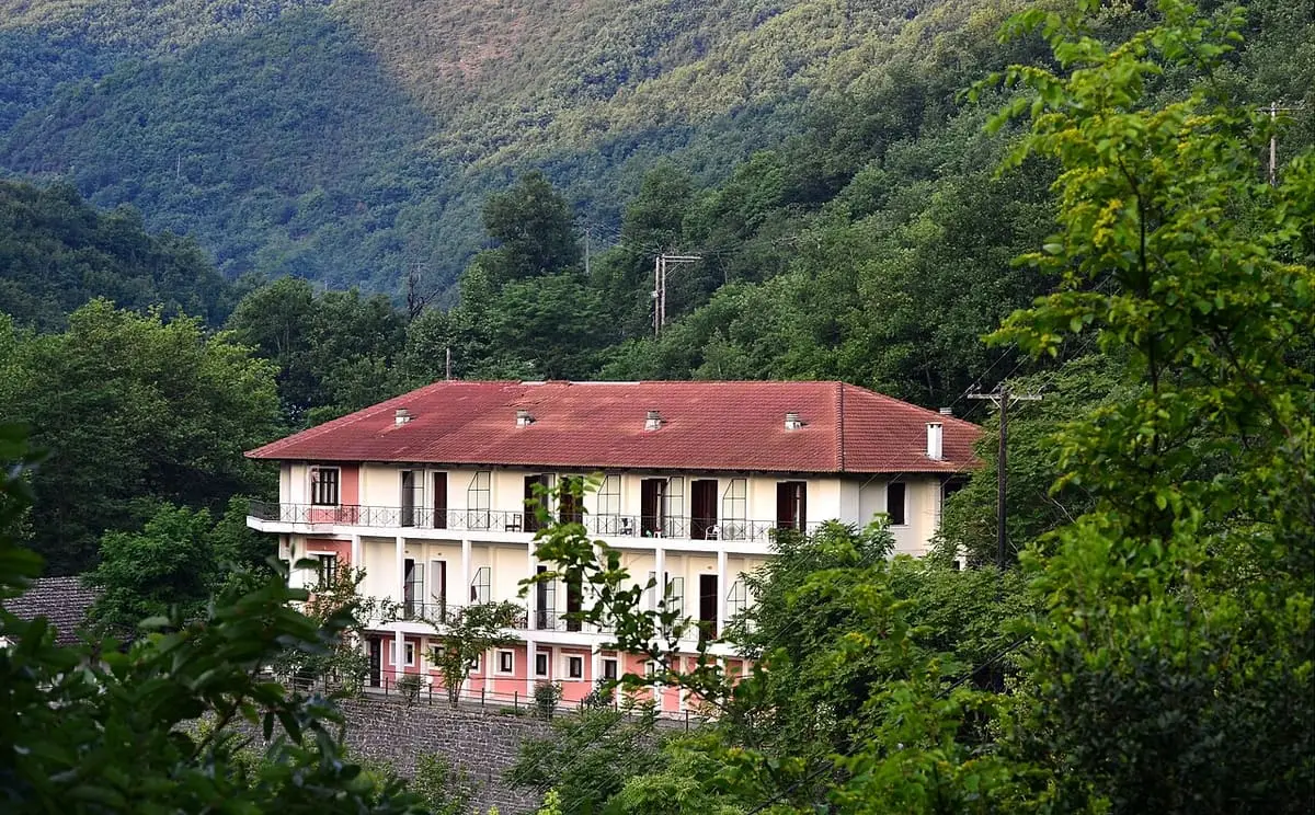 Red roofed Hotel Meteora at Loutra Smokovou among green wooded hillsides