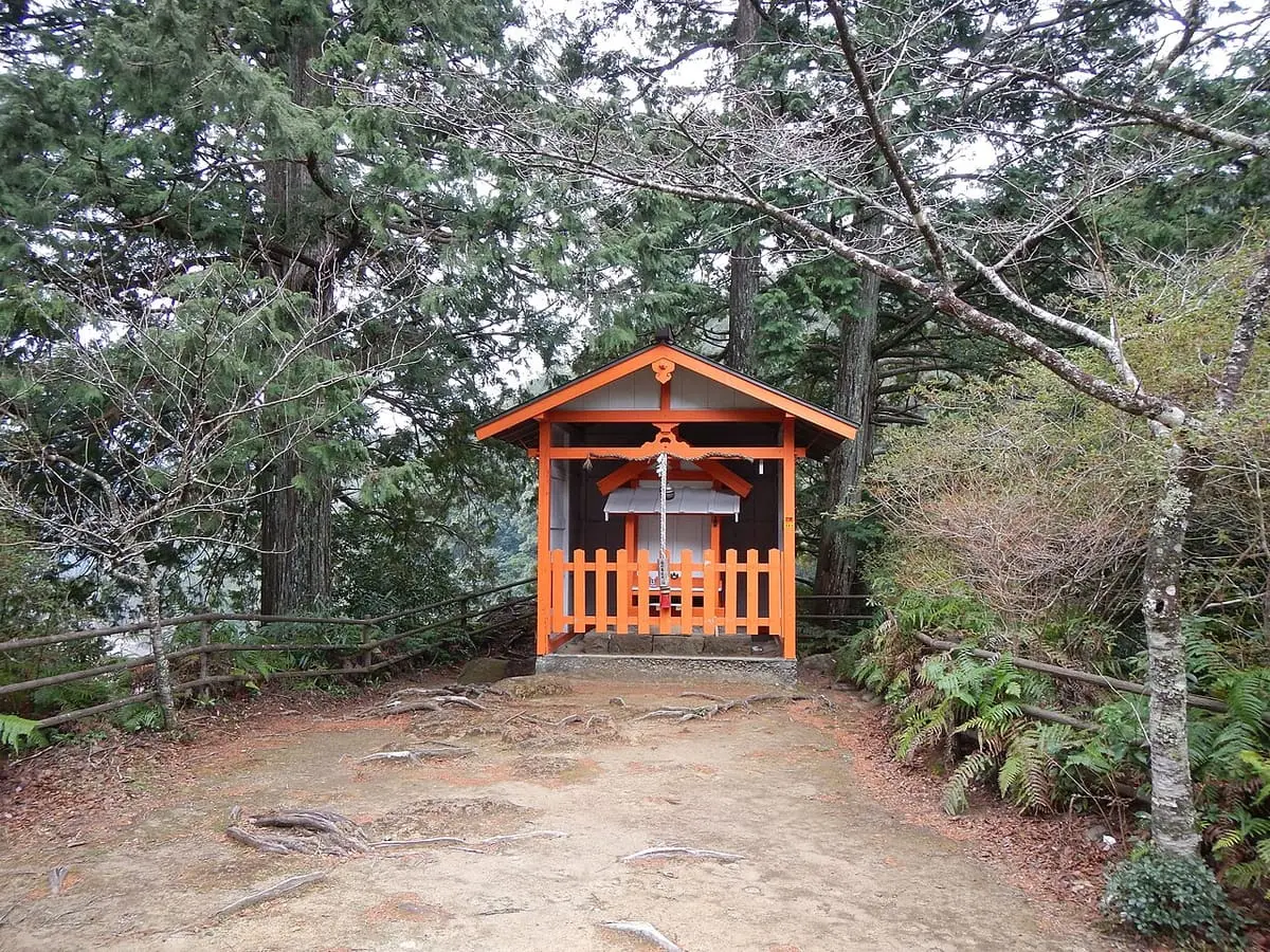 Small orange shrine building among trees at Yunomine Onsen