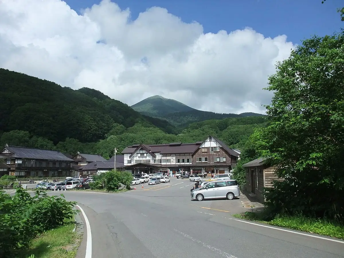 Sukayu Onsen buildings and parking below the green slopes of Odake in the Hakkoda Mountains