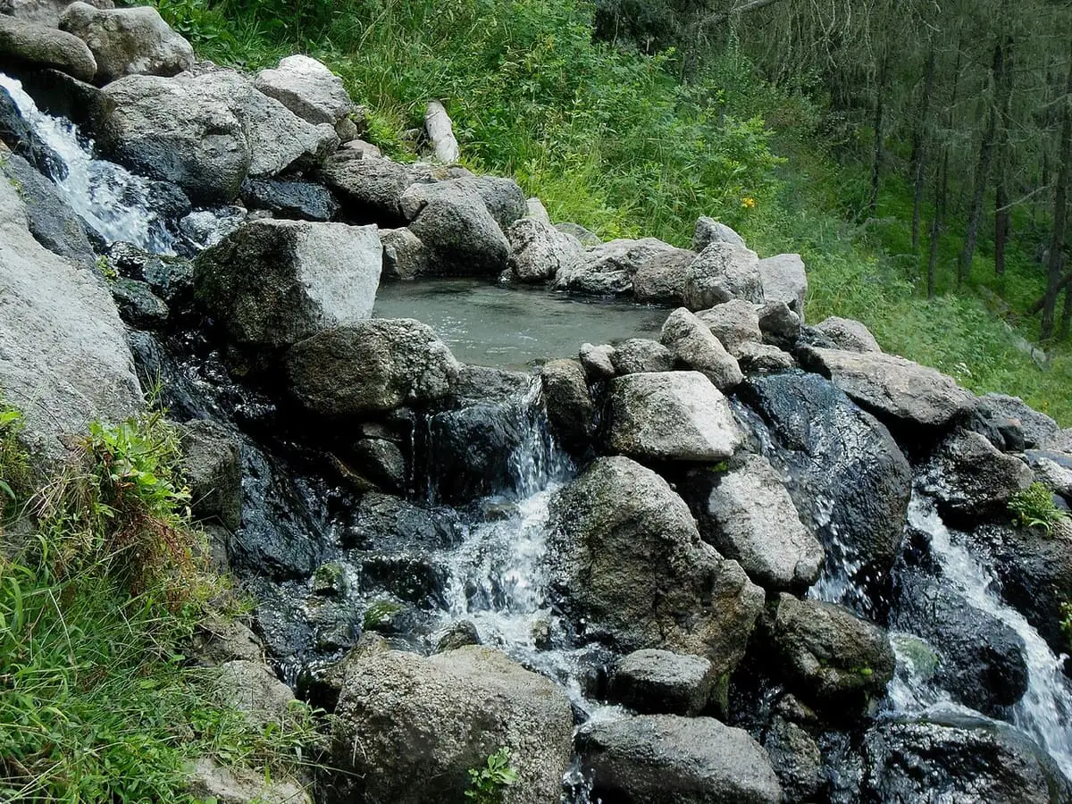 Warm water spilling over boulders from a rock pool at San Antonio Hot Springs