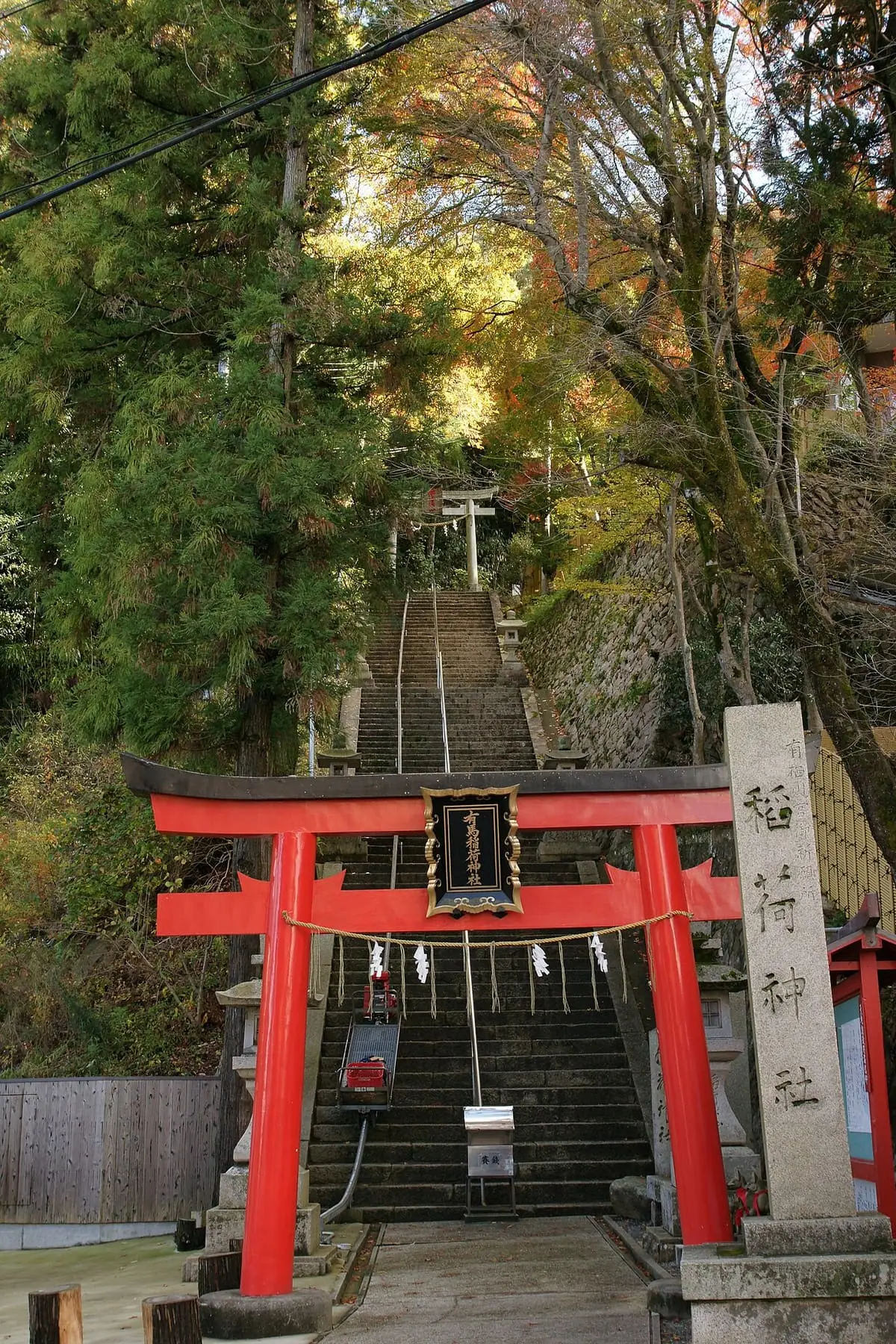 Red torii gate and stone stairway leading up to Arima Inari Shrine in Arima Onsen