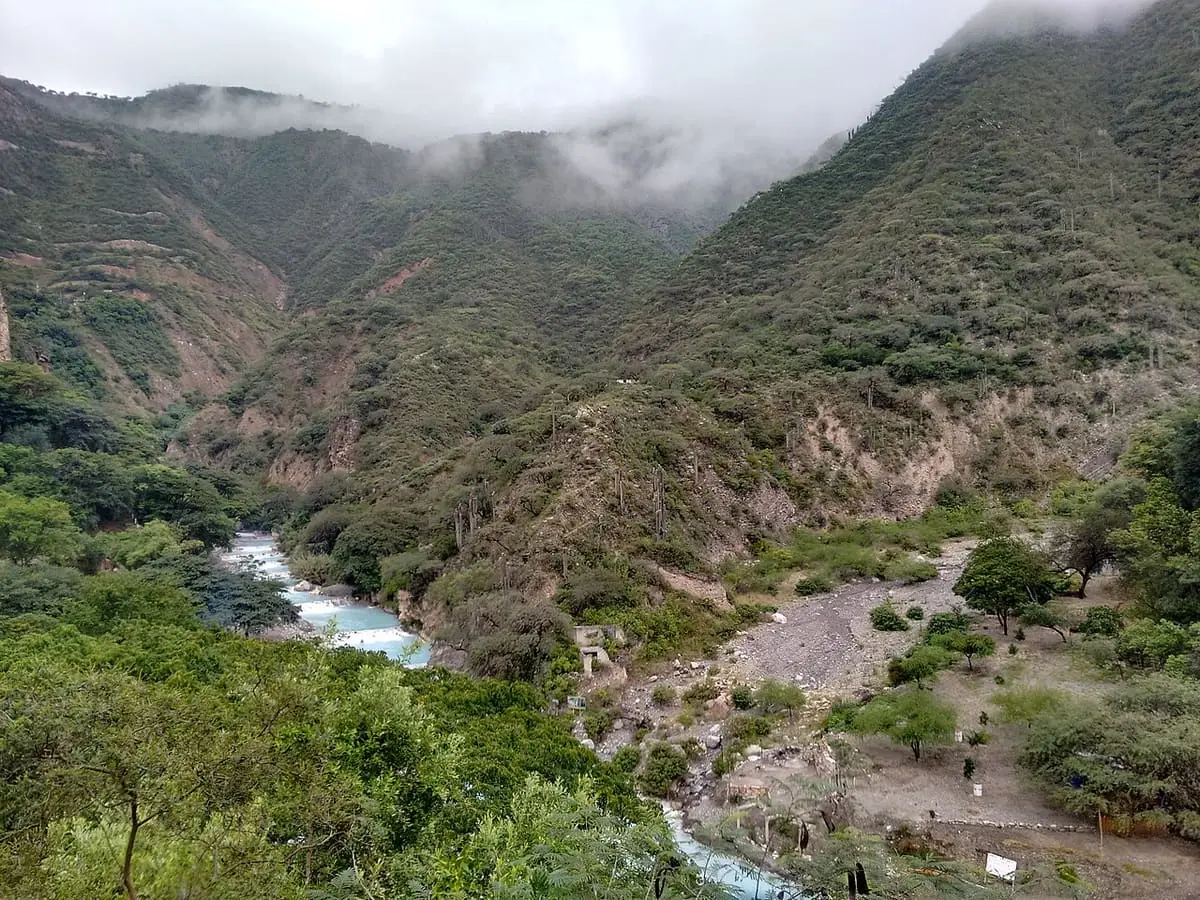 Morning clouds over the green canyon and turquoise river at Grutas Tolantongo