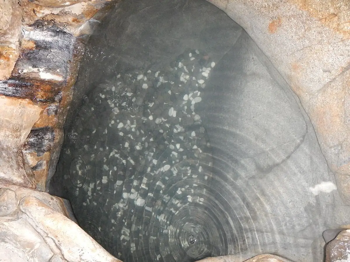 Close view of clear hot water over the smooth rock floor of the Tsuboyu basin