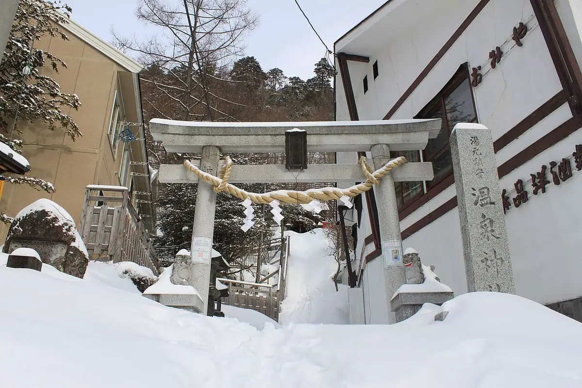 Stone torii of the Onsen Shrine in deep snow at Yumoto Onsen