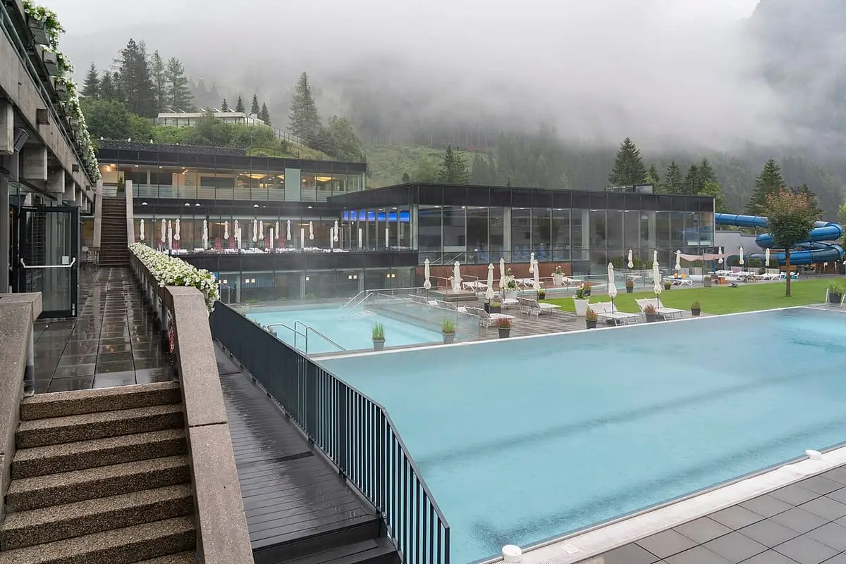 Empty outdoor pool and glass pavilions of the Felsentherme Bad Gastein in fog