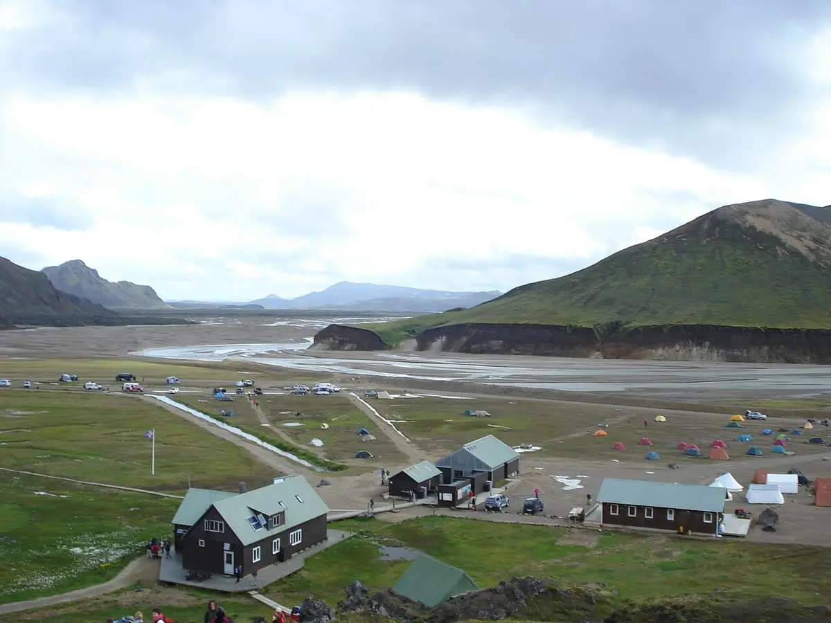 Huts and campsite at Landmannalaugar beside a wide gravel river plain