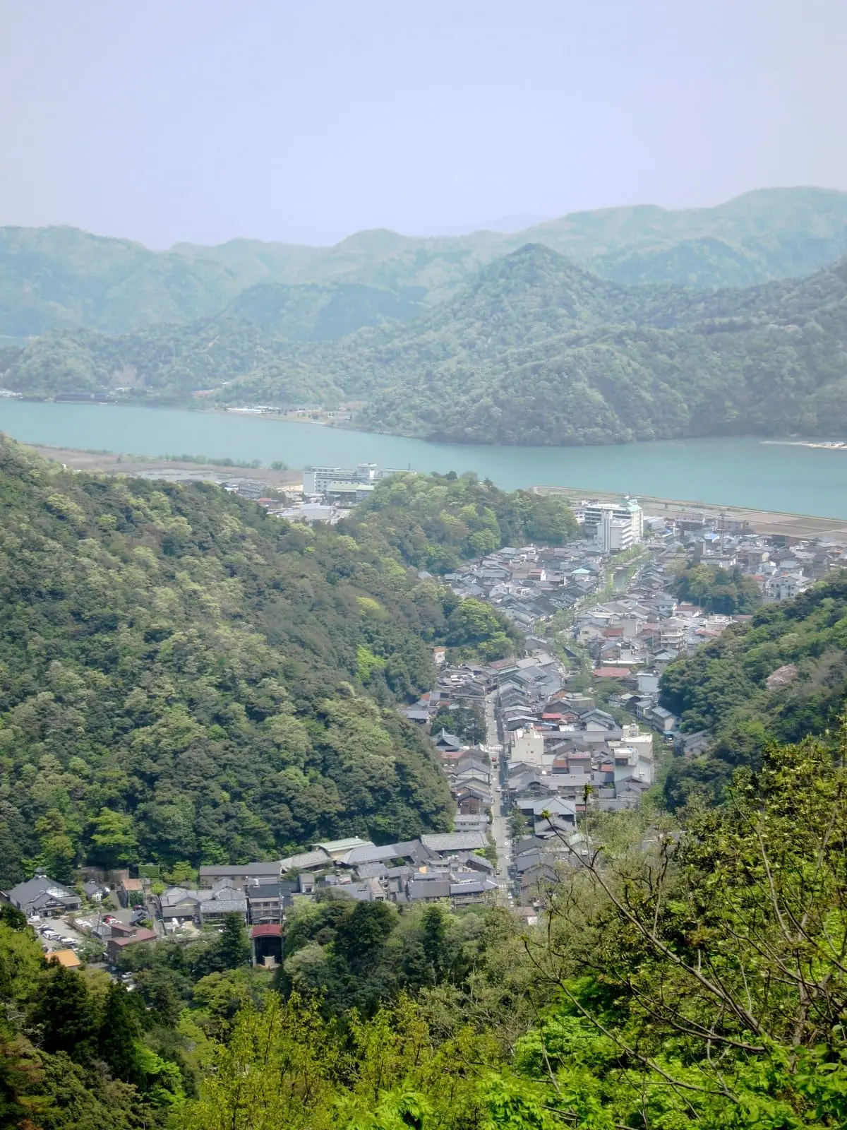 Kinosaki Onsen town spread along a green valley toward the river mouth seen from above