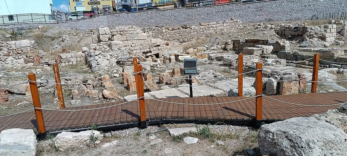 Excavated stone foundations of the Sarıkaya Roman Bath with a wooden walkway and information panels