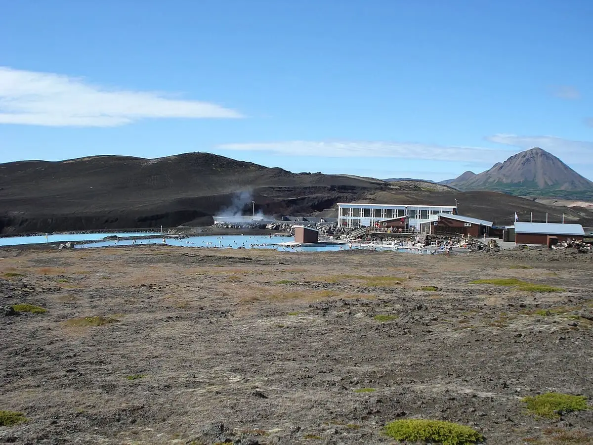 Lagoon buildings and steaming pools on the lava plain east of Lake Mývatn below a mountain