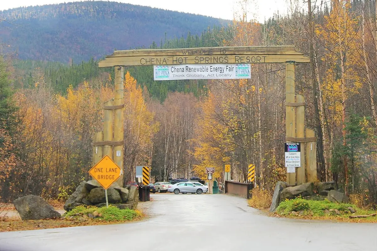 Timber entrance gate to Chena Hot Springs Resort framed by autumn birch and spruce