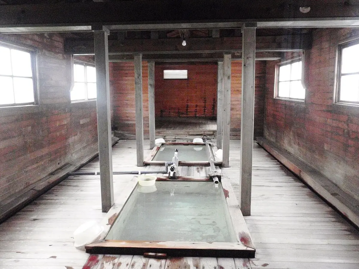 Wooden interior of Furutaki no Yu with a long bath tub at Osorezan