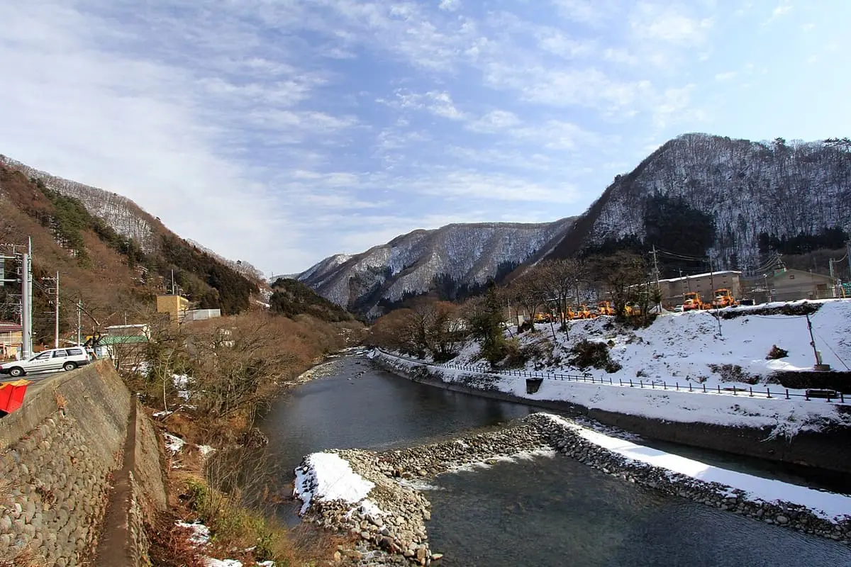 River with snowy banks and rugged mountains near Minakami station