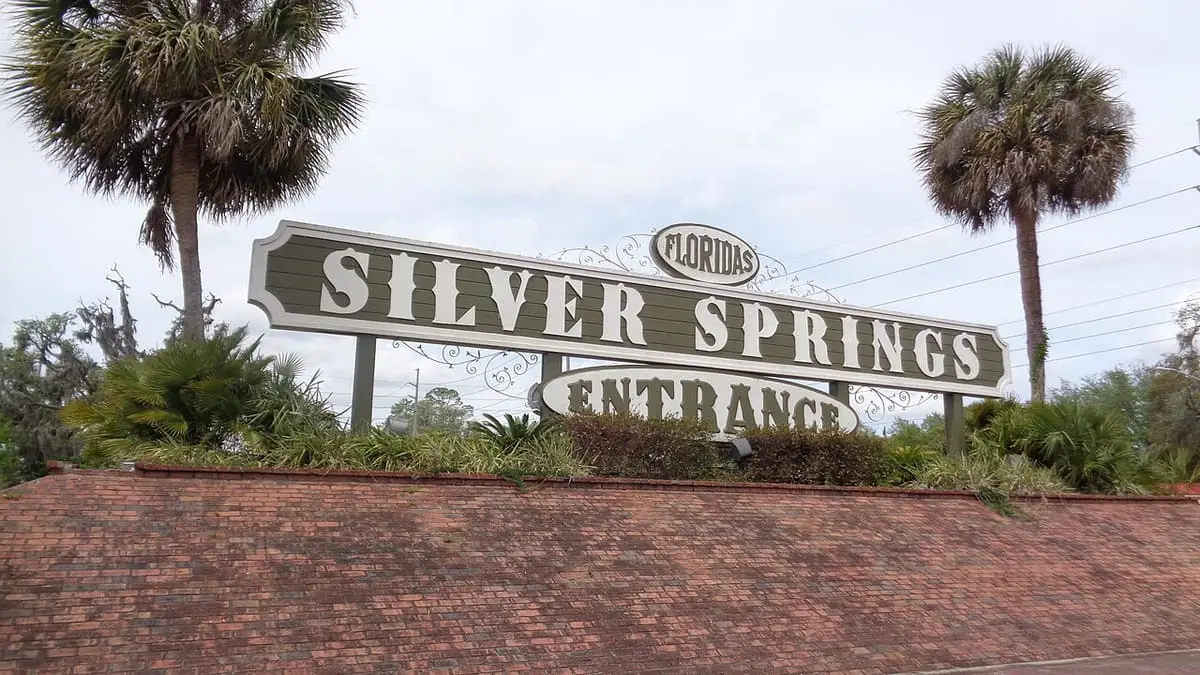 Silver Springs entrance sign with palm trees above a brick wall