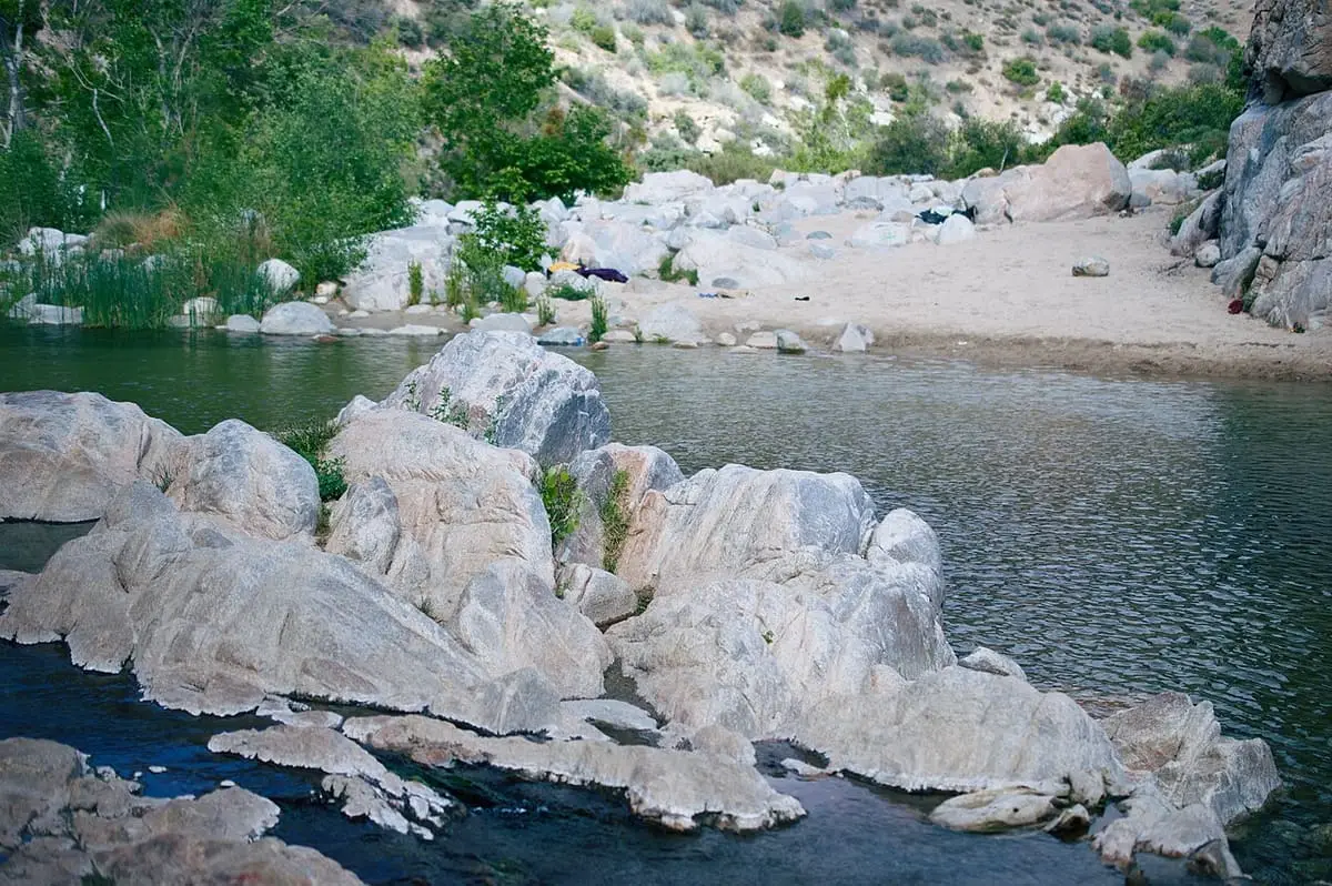 Deep Creek flowing past pale granite boulders and a sandy bank at Deep Creek Hot Springs