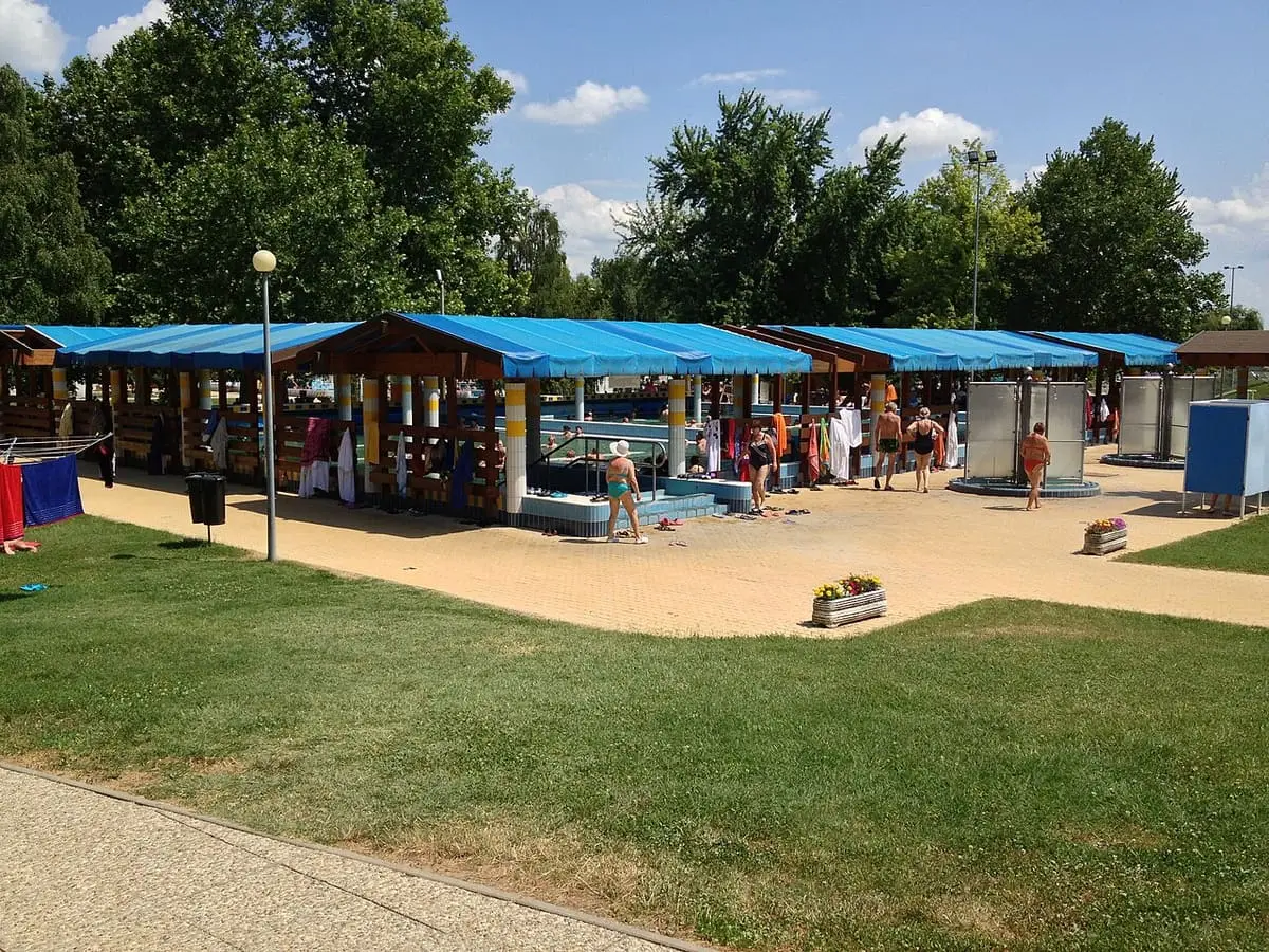 Row of blue roofed pool shelters on the lawn of the Zalakaros thermal lido